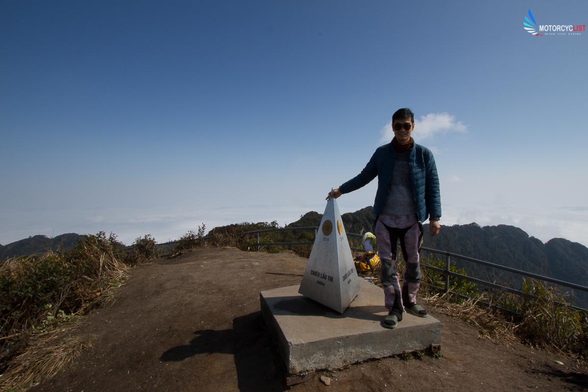 Motorcyclist standing at Chieu Lau Thi peak